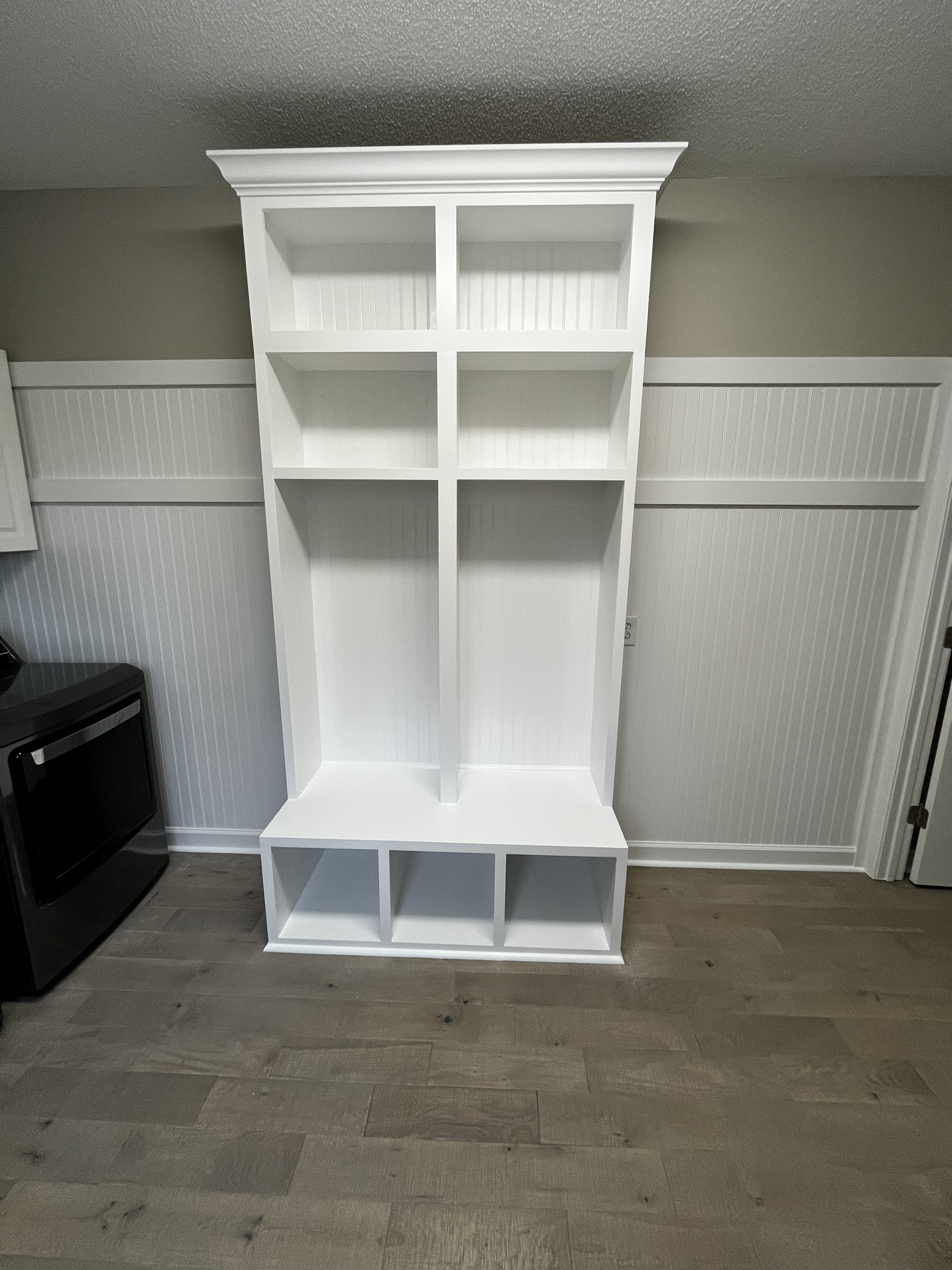 Custom built-in storage with beadboard wainscoting and crown molding